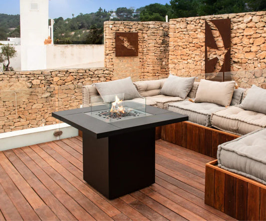 Moderne vuurtafel buiten in een sfeervolle Nederlandse tuin, omringd door comfortabele tuinmeubelen en warme verlichting.