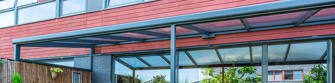Aluminium overkapping in antraciet op een terras, voorzien van opaal polycarbonaat dak, aan huis geplaatst.