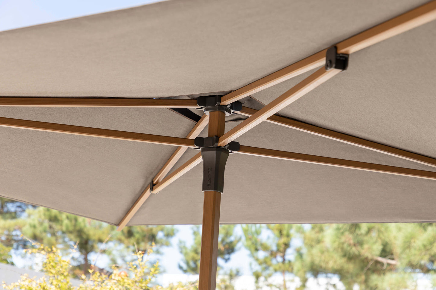 Close-up van een elegante outdoor parasol met een teakhouten frame en parelgrijze stof, 230x230 cm, perfect voor stijlvol buitengebruik.