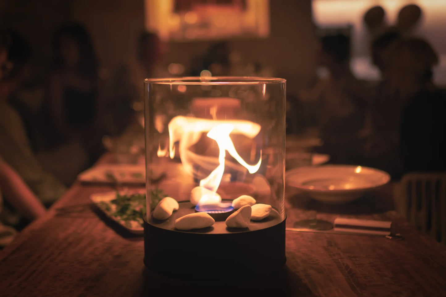Planika Chantico Glassfire bioethanol tafelhaard met zwart stalen basis en glazen cilinder – moderne en compacte designhaard.