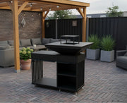 Close-up van de Kratki Quadrum Horizontale buitenhaard met grillfunctie, een houtgestookte BBQ en vuurplaats, staand op een modern Nederlands terras met houten overkapping.