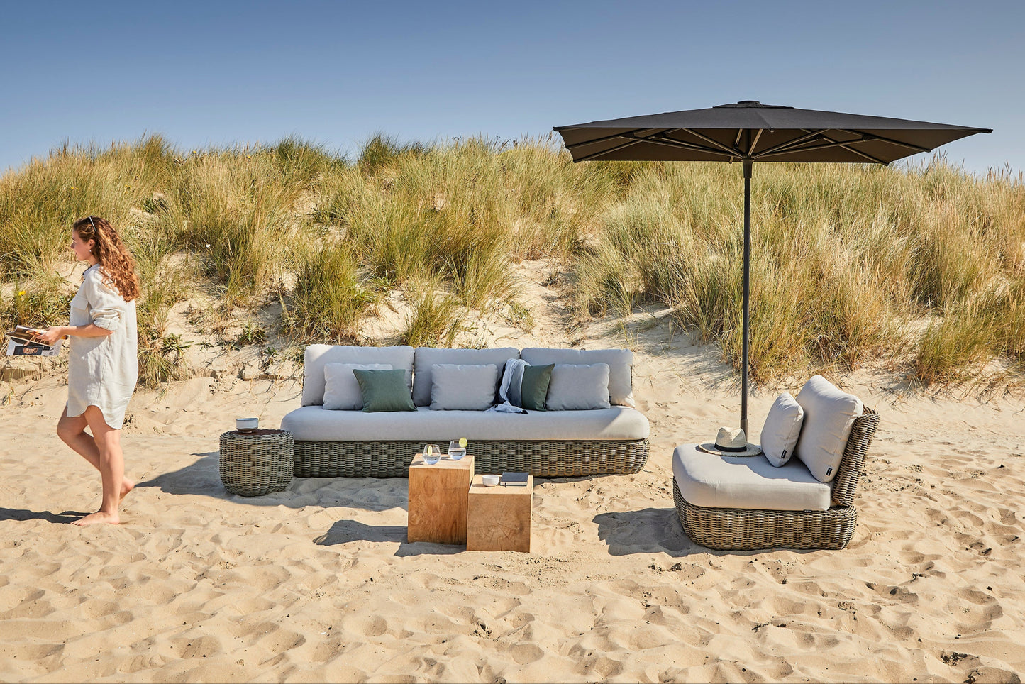 Tugu Loungebank 3-Zits van Jardinico op een luxe terras, met handgeweven Cottage F16 wicker en all-weather kussens in Linen C008.