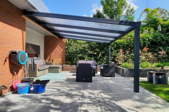 Zijaanzicht van YARD Outdoor aluminium veranda met 3 staanders en duurzaam opaal polycarbonaat dak.
