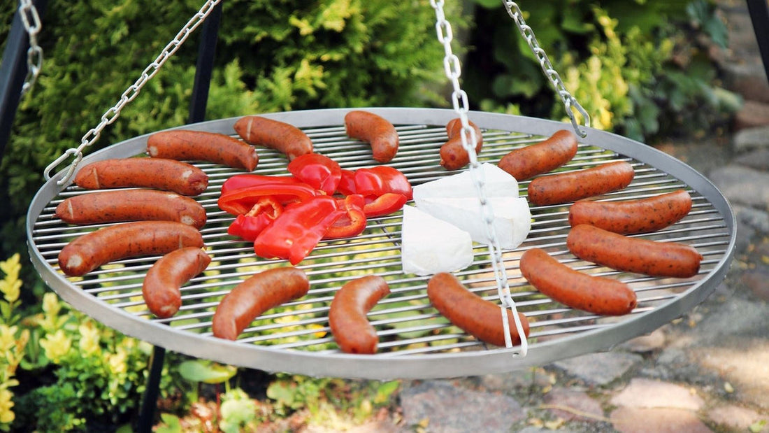 RVS grillrooster van CookKing met worstjes en paprika aan een driepoot