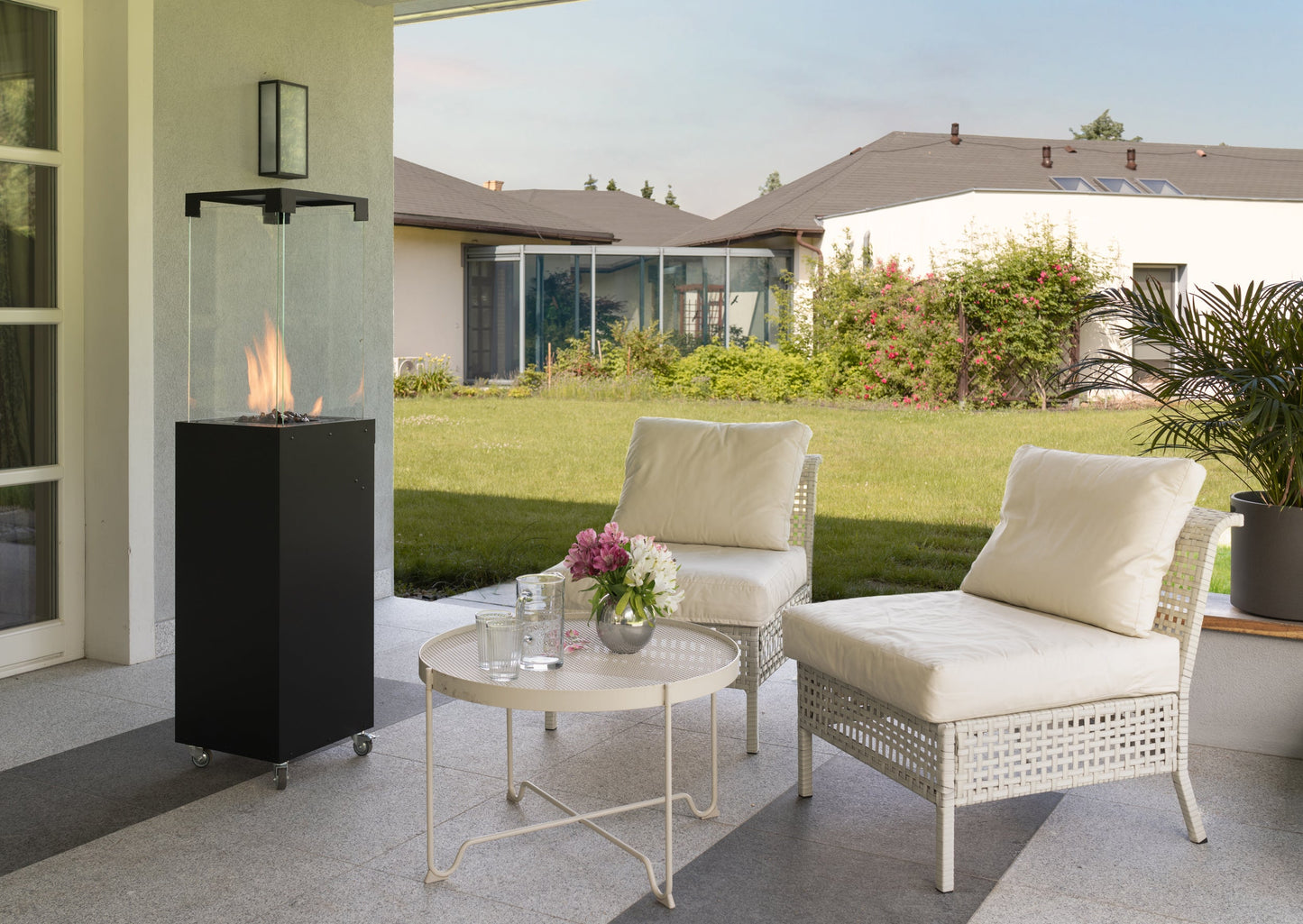 De Faro Buitenhaard in een groene tuin, omringd door planten en perfect voor gezellige buitenmomenten.