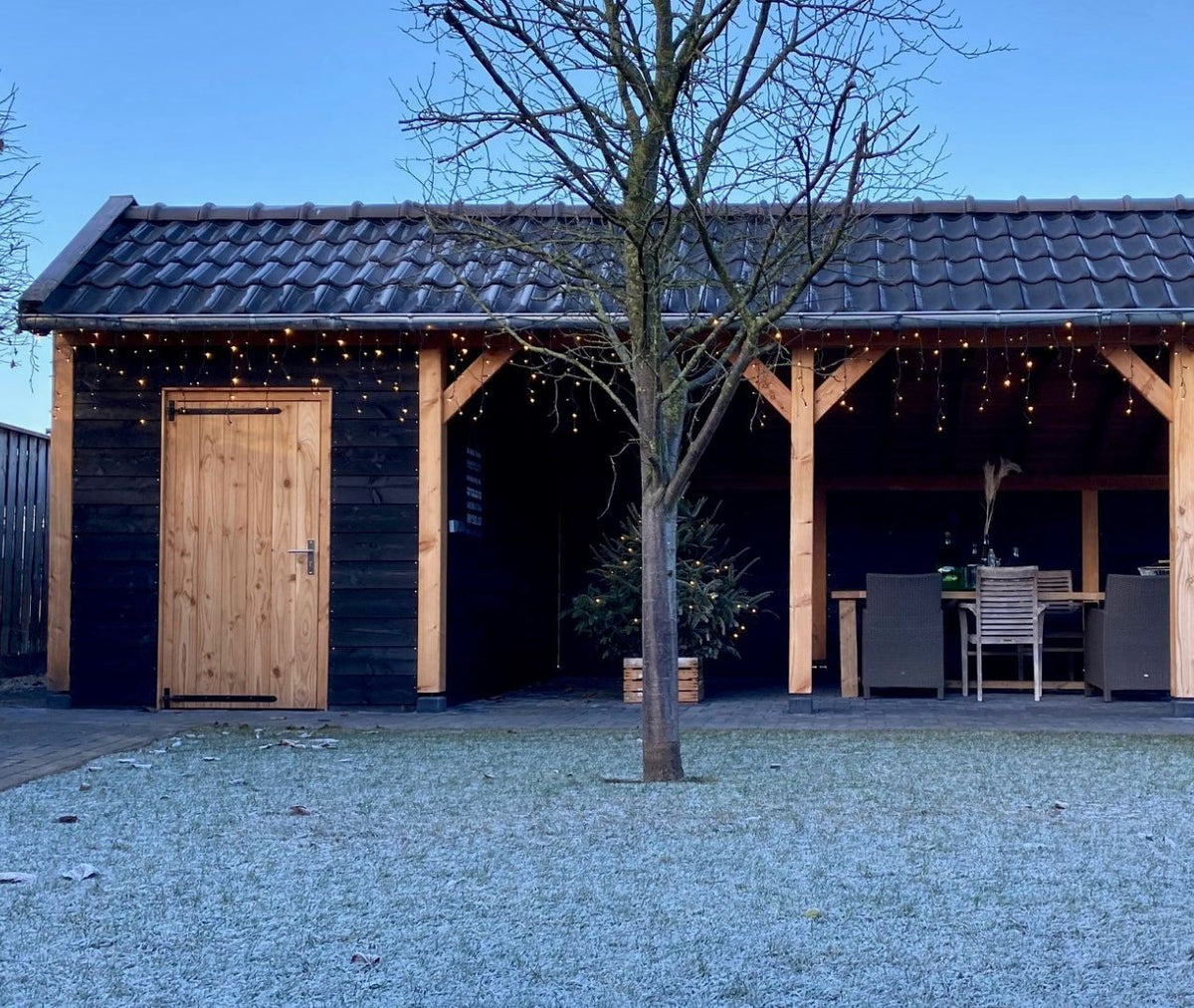 Douglas kapschuur met dichte berging, zwarte rabatwanden en eethoek in de winter