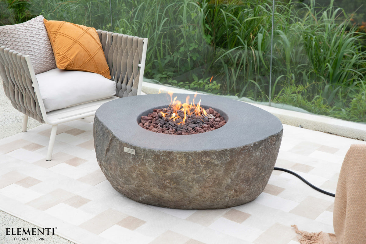 Elementi Boulder Gas-Feuertisch mit brennender Flamme in einer hellen Outdoor-Lounge