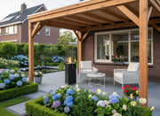 Elegante mobiele gas terrasverwarmer Faro op een terras tussen planten en tuinmeubels, met zichtbare vlam door gehard glas
