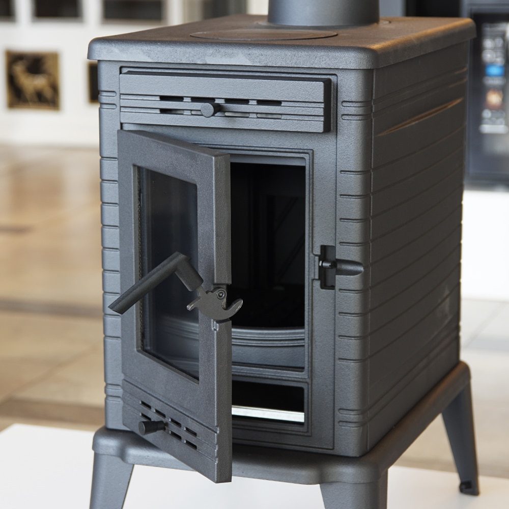 Kratki KOZA K10 houtkachel in een woonkamer met houten vloer