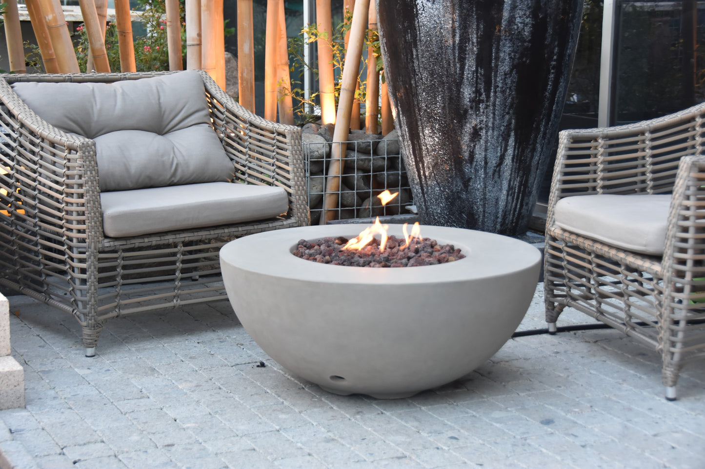 Modeno Roca grijze ronde vuurtafel op gas in een loungehoek op het terras