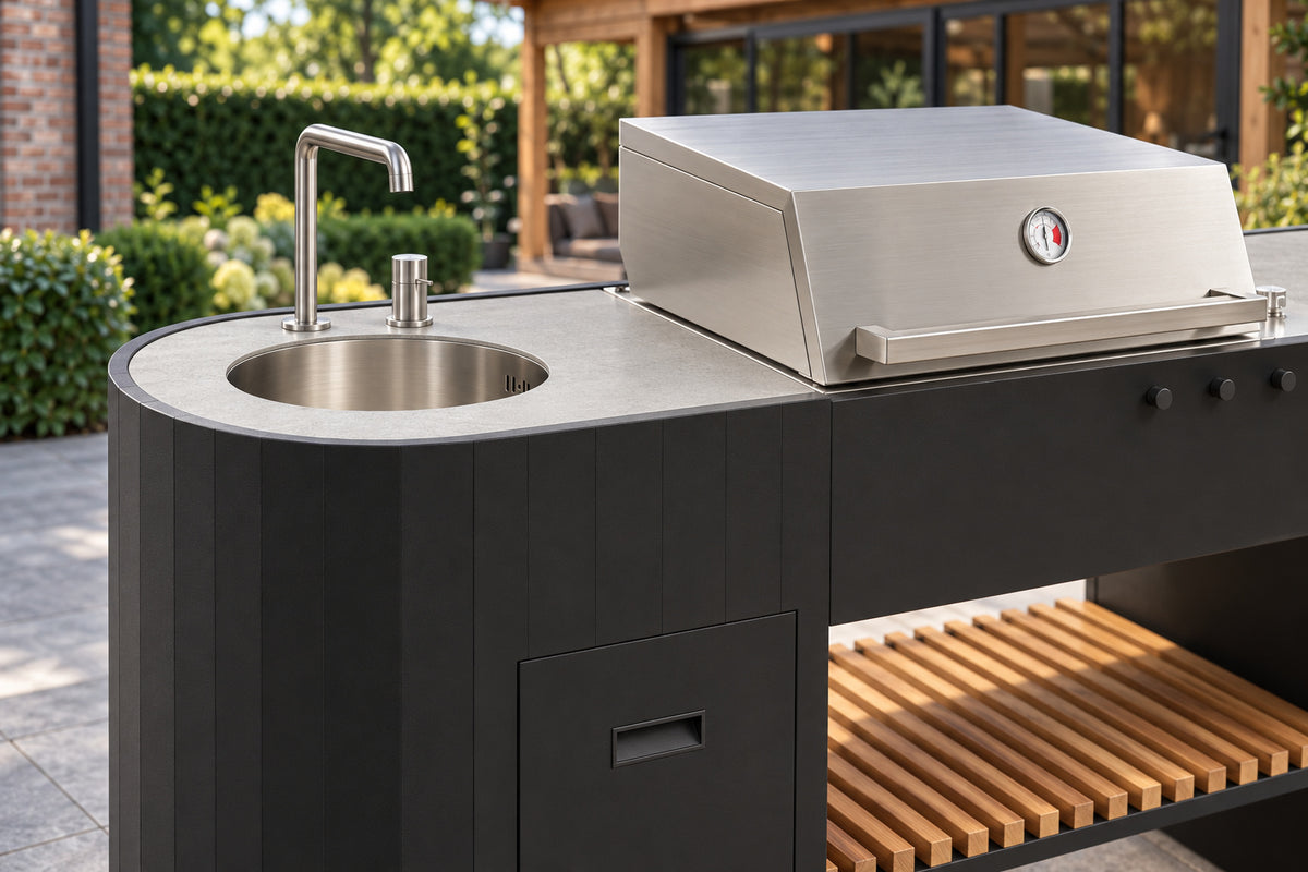 Close-up Q-boo OVO GL buitenkeuken: RVS spoelbak met kraan naast de gasbarbecue en Dekton werkblad