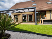 Aluminium terrasoverkapping met polycarbonaat dak geplaatst in een sfeervolle achtertuin