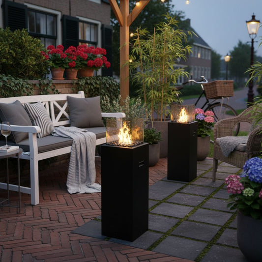 Vrijstaande zwarte bio-ethanolhaard TOWER op een terras in de namiddag, moderne sfeerhaard voor buiten met natuurlijk vlammenspel.
